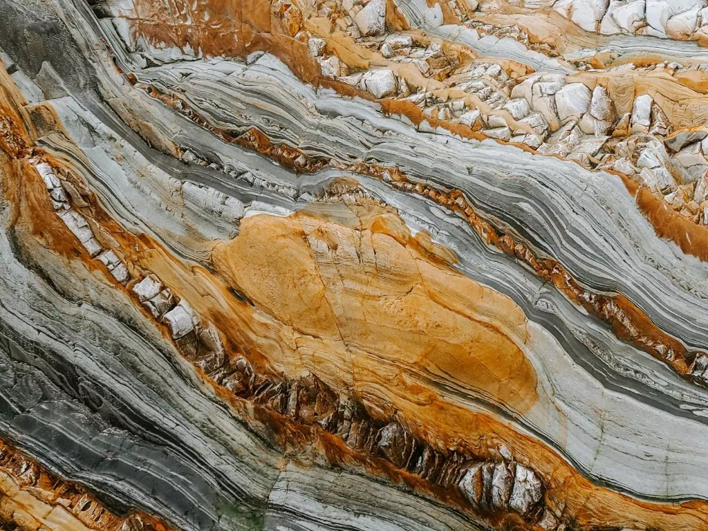 Close-up of folded and layered rock formations revealing the geological history of a mineral system
